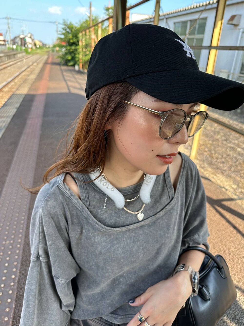 ブラック系のサンダル、ブラック系のデニムパンツ、グレー系のTシャツ/カットソーを着用したレディースの夏コーディネートの4枚目の写真