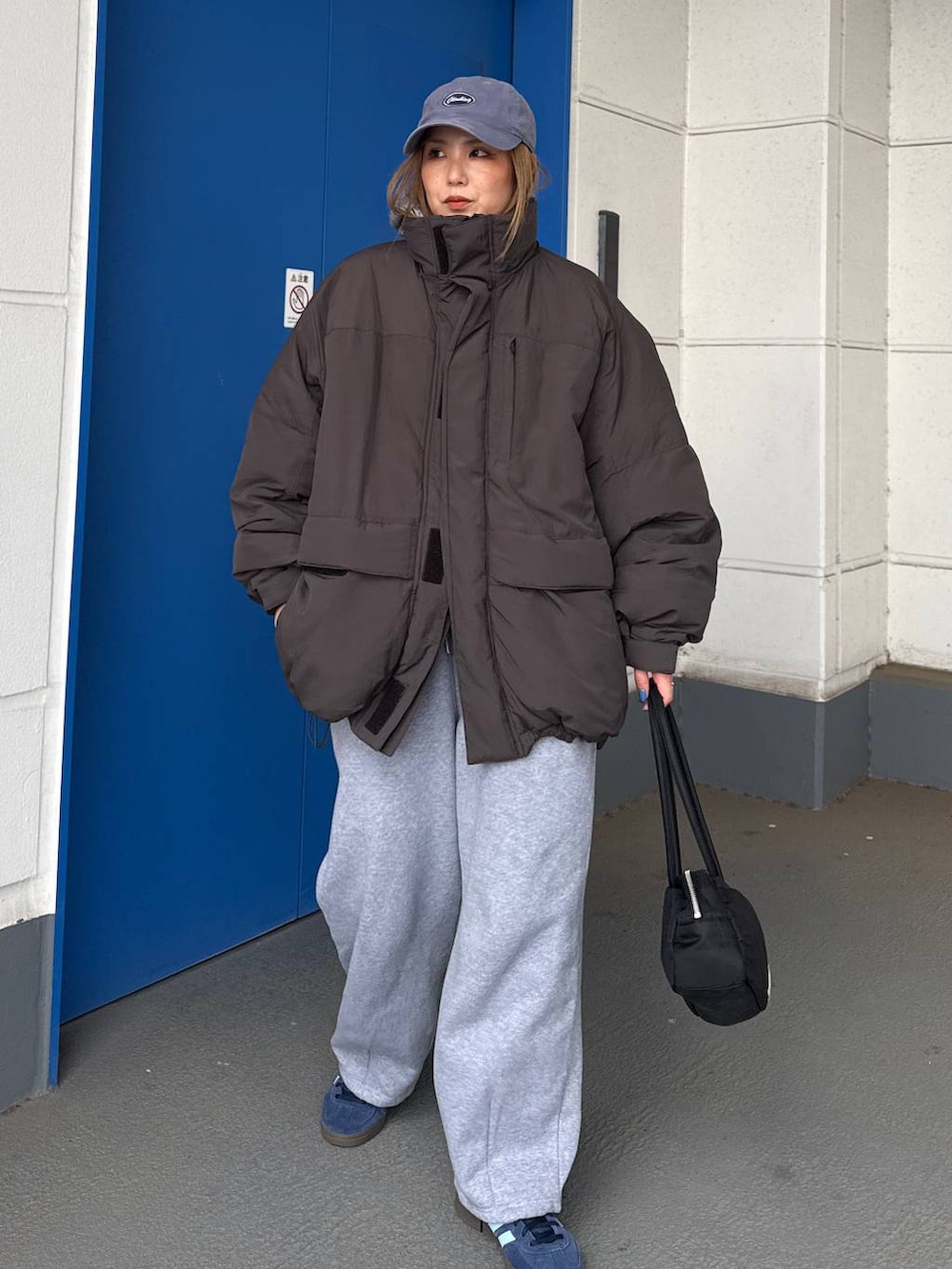 グレー系のダウンジャケット/コート、グレー系のスウェットパンツを着用したレディースの冬コーディネートの2枚目の写真