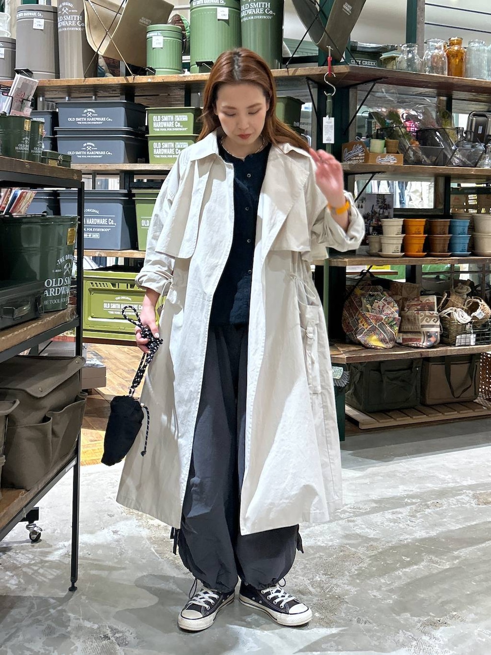 ブラック系のショルダーバッグ、グレー系のトレンチコート、ブラック系のシャツ/ブラウスを着用したレディースの春コーディネートの3枚目の写真