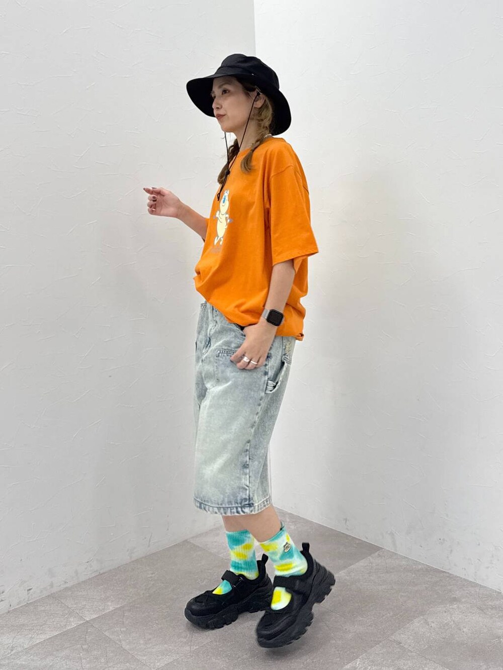 ブラック系のスニーカー、ブルー系のデニムパンツ、ブラック系のハットを着用したレディースの夏コーディネートの2枚目の写真