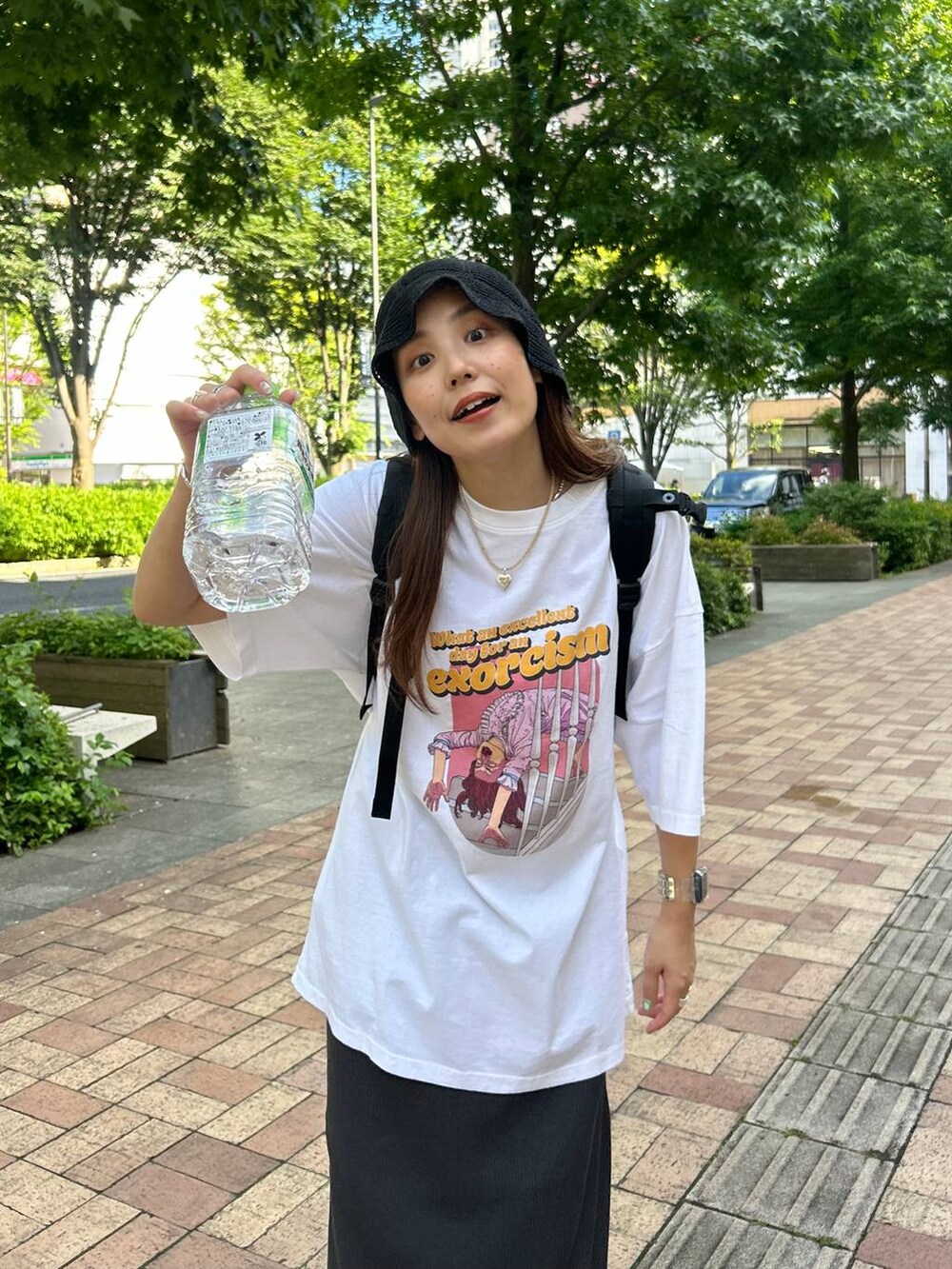 ホワイト系のTシャツ/カットソー、グレー系のスカート、ブラック系のサンダルを着用したレディースの夏コーディネートの3枚目の写真