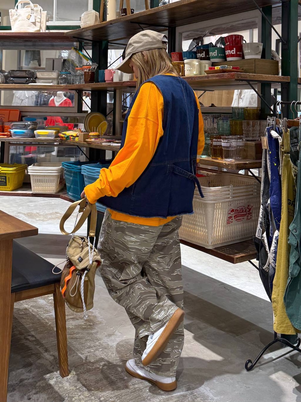 ブルー系のベスト、ベージュ系のキャップを着用したレディースの春コーディネートの5枚目の写真