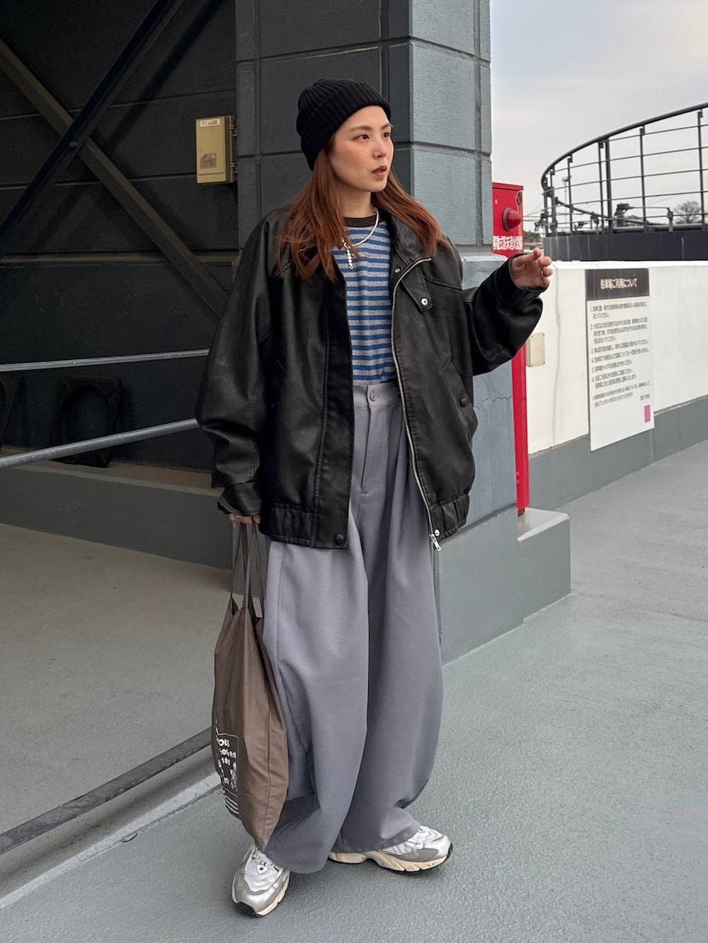 ブラック系のライダースジャケット、ブルー系のニット/セーターを着用したレディースの冬コーディネートの2枚目の写真