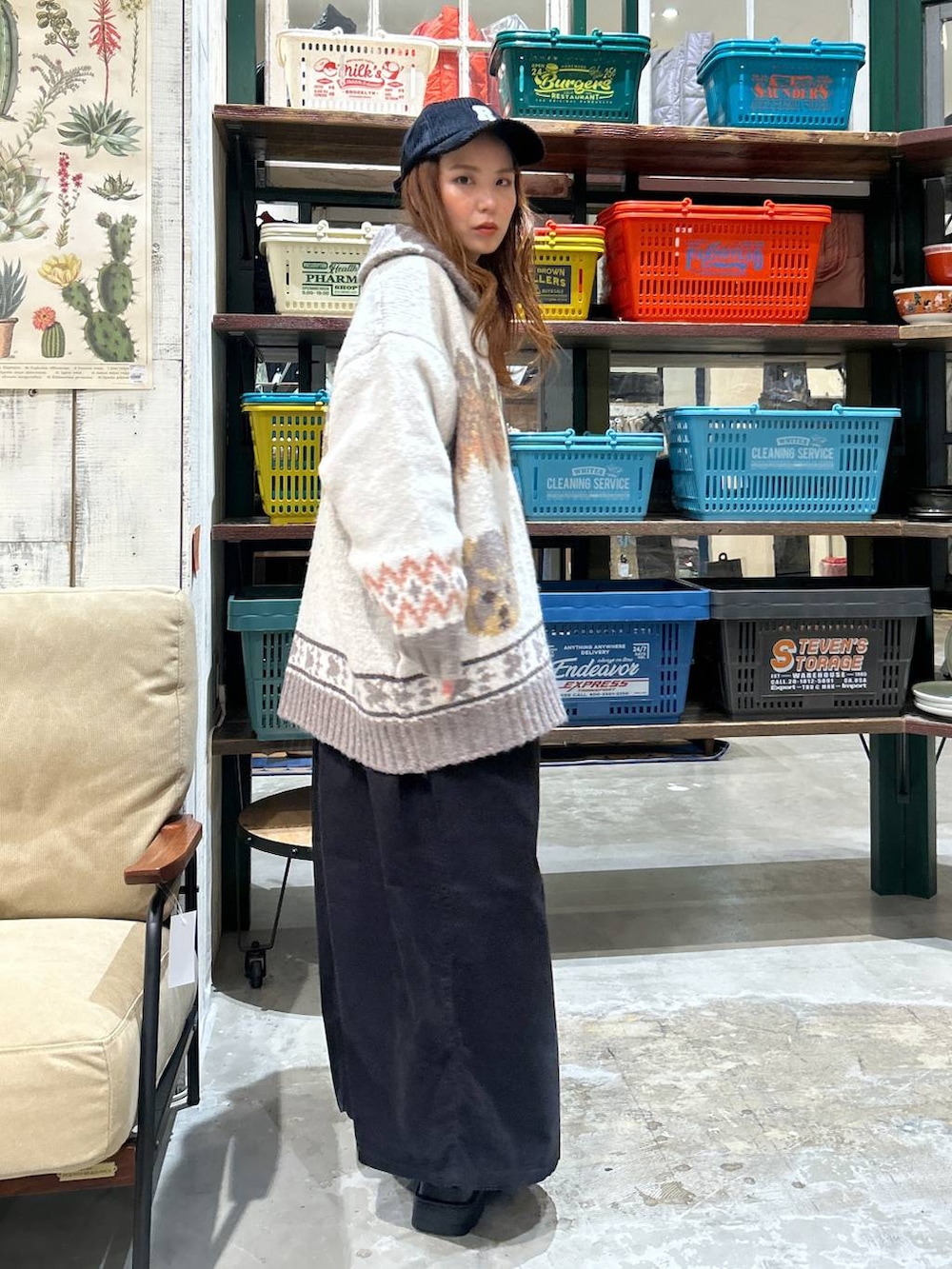 ブラック系のワンピース、ベージュ系のブーツ、ブラック系のキャップを着用したレディースの秋コーディネートの4枚目の写真