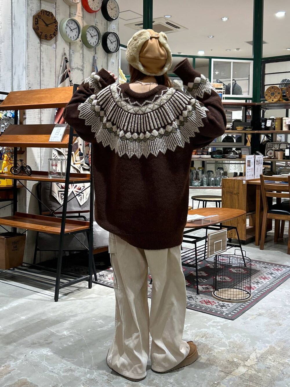 ベージュ系のカーゴパンツ、ブラウン系のニット/セーター、ベージュ系のキャップを着用したレディースの冬コーディネートの4枚目の写真