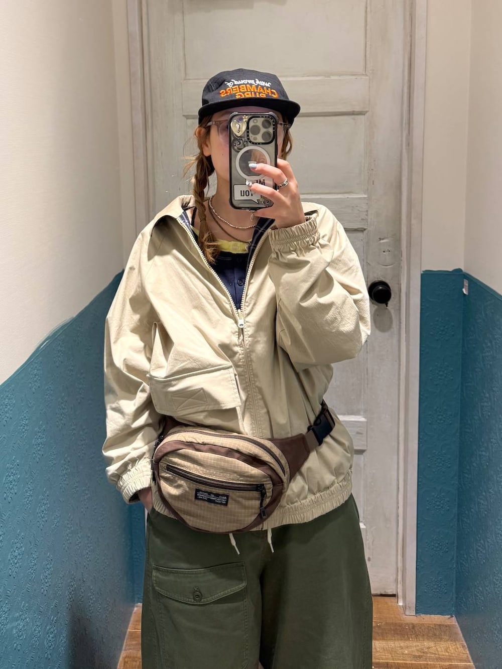 イエロー系のブルゾン、ブルー系のTシャツ/カットソー、ベージュ系のボディバッグ/ウエストポーチを着用したレディースの冬コーディネートの3枚目の写真