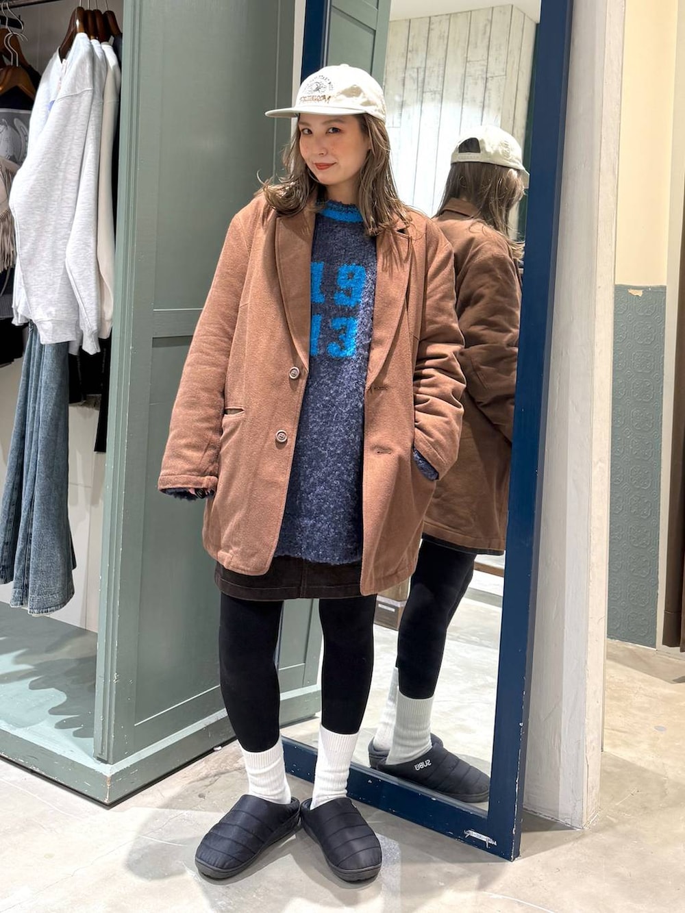 ブラウン系のスカート、ブラウン系のテーラードジャケット、ホワイト系のキャップを着用したレディースの秋コーディネートの2枚目の写真