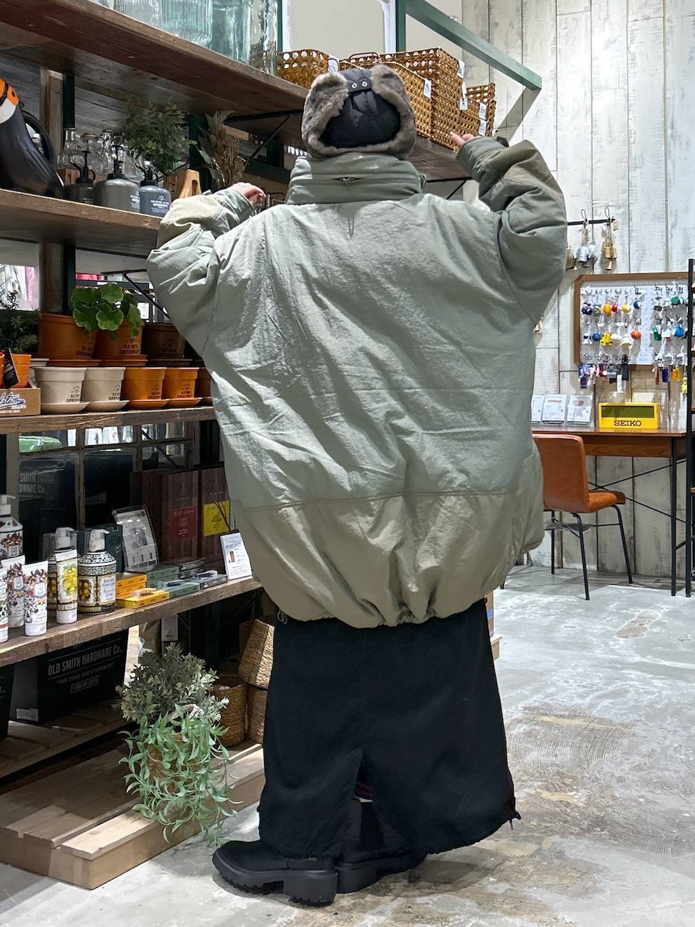 グリーン系のブルゾン、ブラック系のブーツ、ホワイト系のTシャツ/カットソーを着用したレディースの冬コーディネートの3枚目の写真