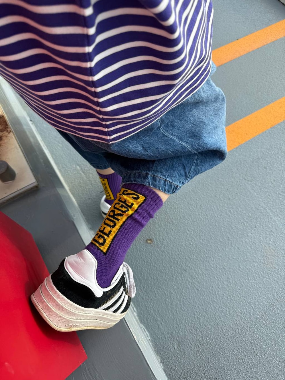 ベージュ系のショルダーバッグ、ブルー系のデニムパンツ、ブラック系のキャップを着用したレディースの春コーディネートの4枚目の写真