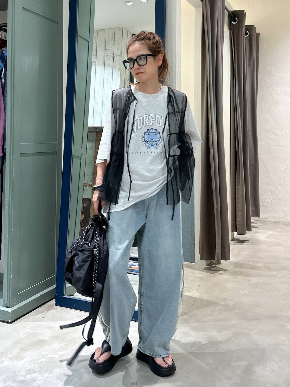 ブラック系のサンダル、ベージュ系のTシャツ/カットソー、ブラック系のベストを着用したレディースの夏コーディネートの2枚目の写真