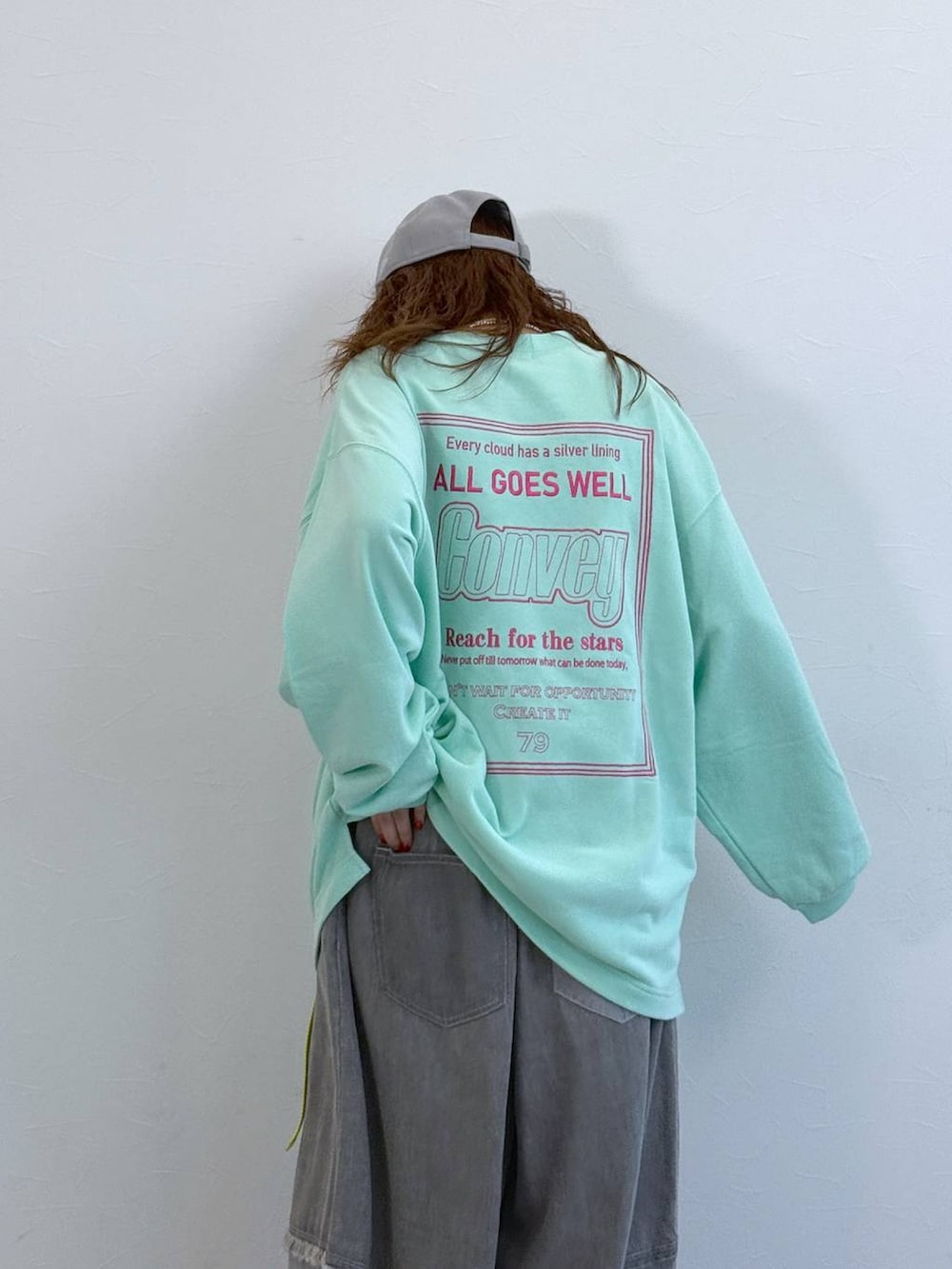 グレー系のデニムパンツ、グリーン系のTシャツ/カットソーを着用したレディースの冬コーディネートの3枚目の写真