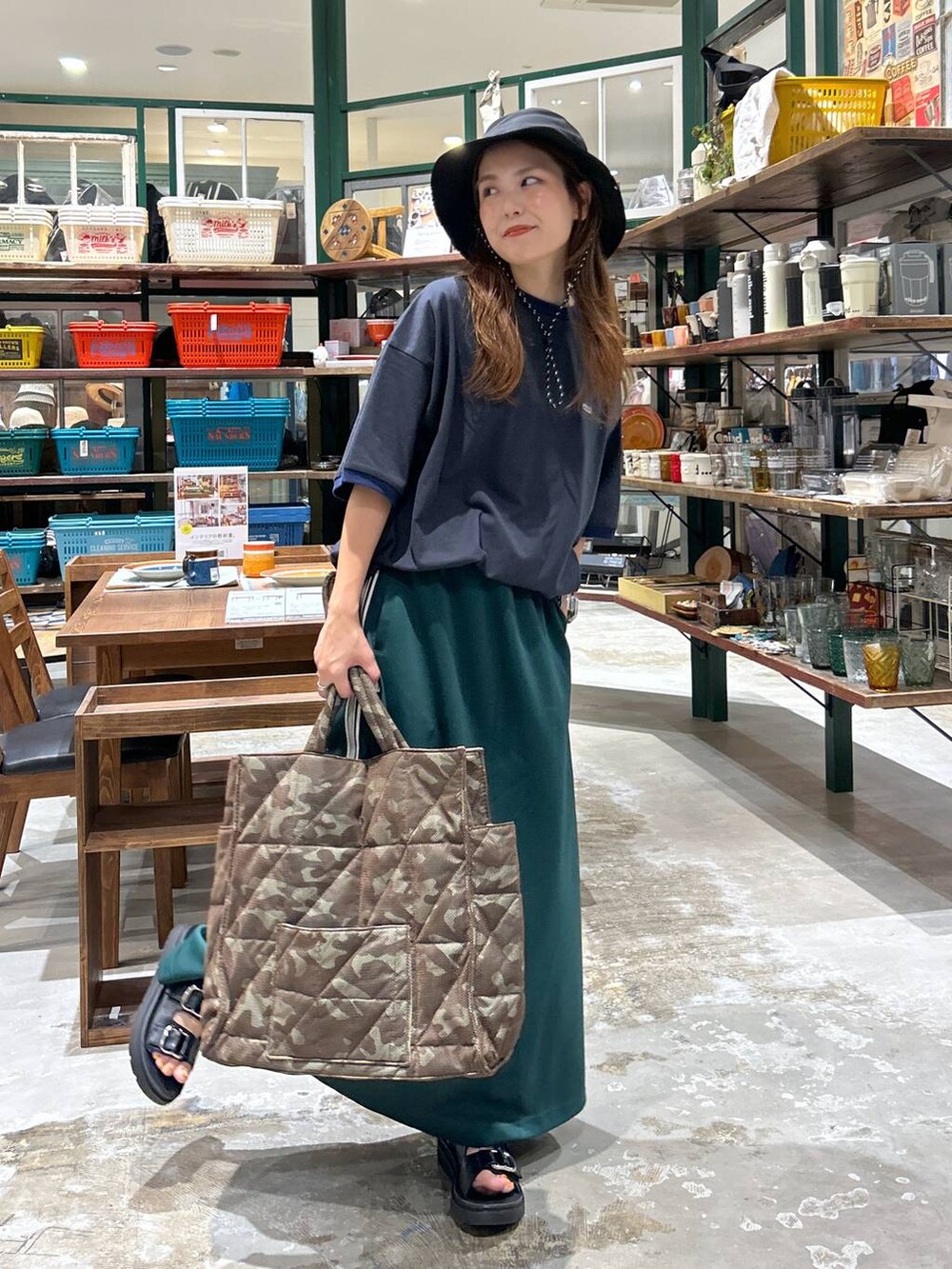 ブラック系のサンダル、ブラウン系のトートバッグ、グリーン系のスカートを着用したレディースの夏コーディネートの2枚目の写真