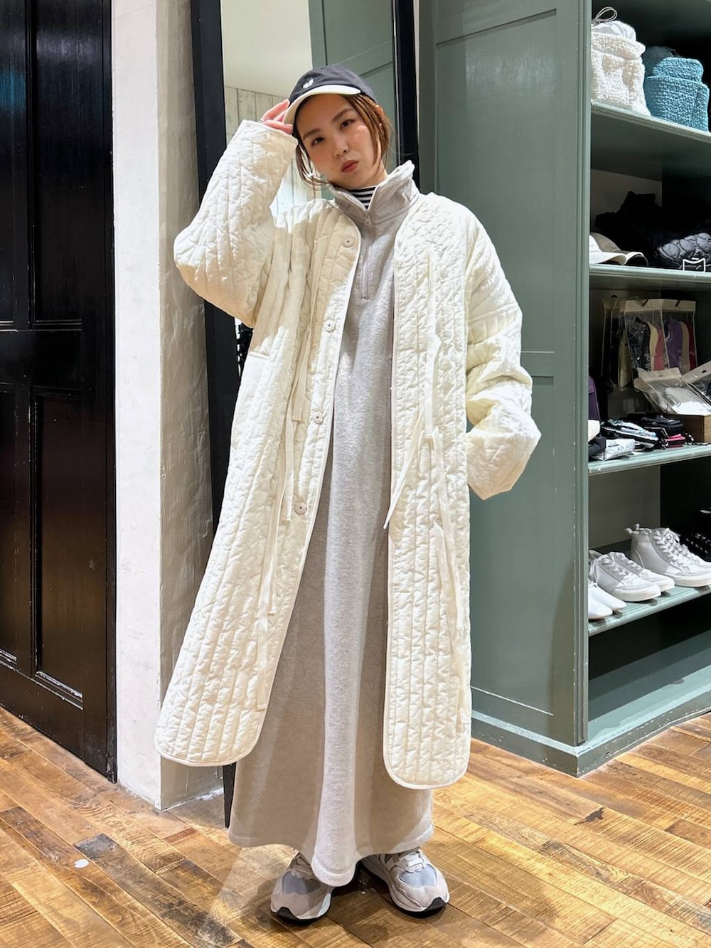 ホワイト系のノーカラーコート、ホワイト系のTシャツ/カットソー、ベージュ系のワンピースを着用したレディースの冬コーディネートの2枚目の写真