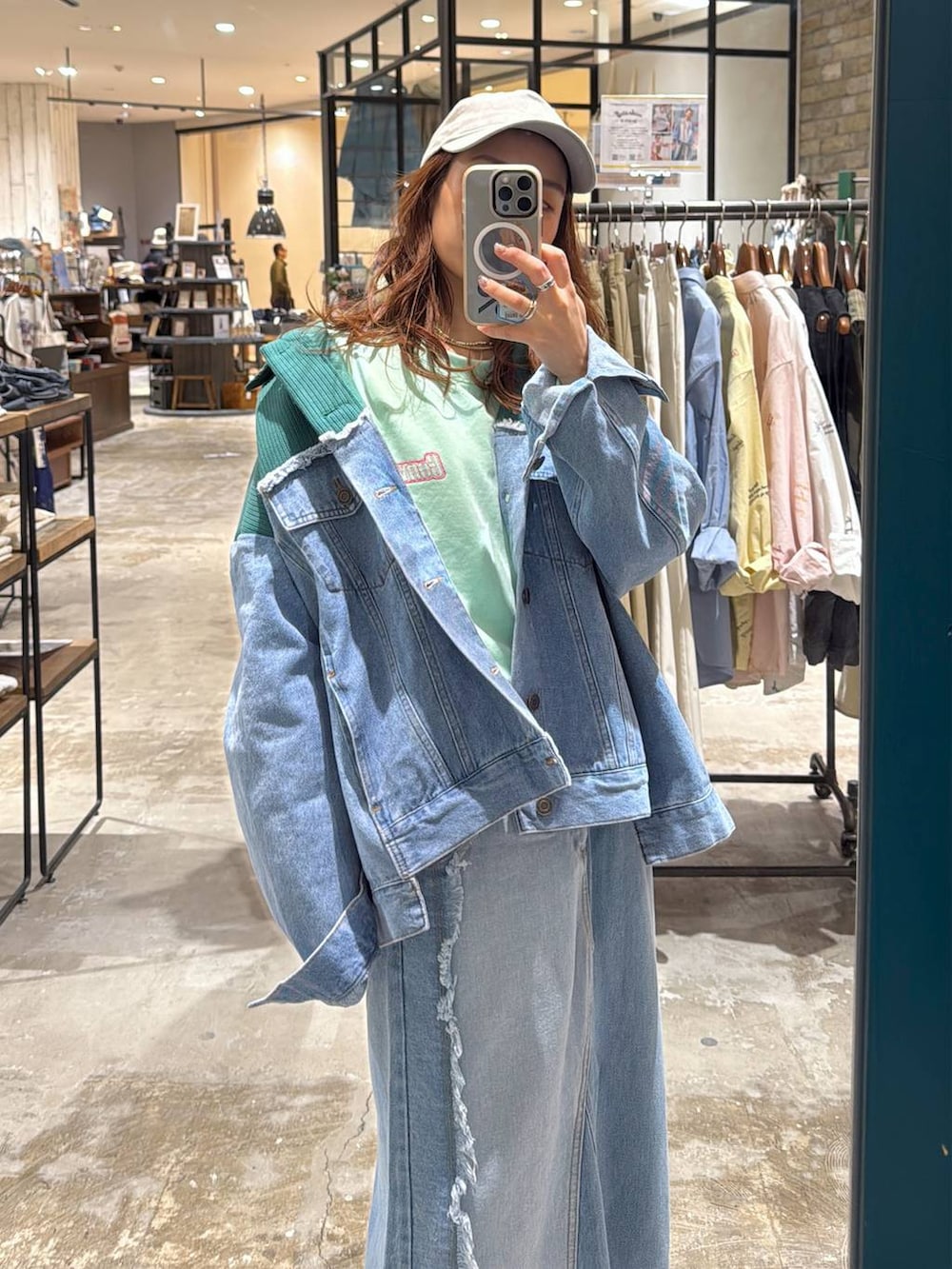 ブルー系のデニムジャケット、ブルー系のデニムスカート、グリーン系のTシャツ/カットソーを着用したレディースの冬コーディネートの2枚目の写真