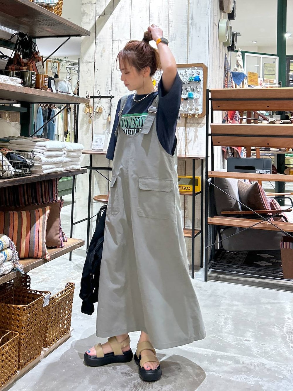 ブラック系のショルダーバッグ、イエロー系のサンダル、ブルー系のTシャツ/カットソーを着用したレディースの春コーディネートの3枚目の写真