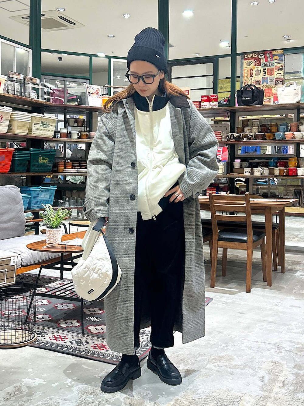 ブラック系のローファー、グレー系のステンカラーコート、ベージュ系のショルダーバッグを着用したレディースの冬コーディネートの2枚目の写真