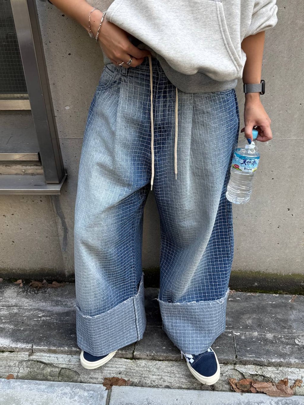 ベージュ系のパーカー、ブルー系のデニムパンツ、その他のキャップを着用したレディースの秋コーディネートの5枚目の写真