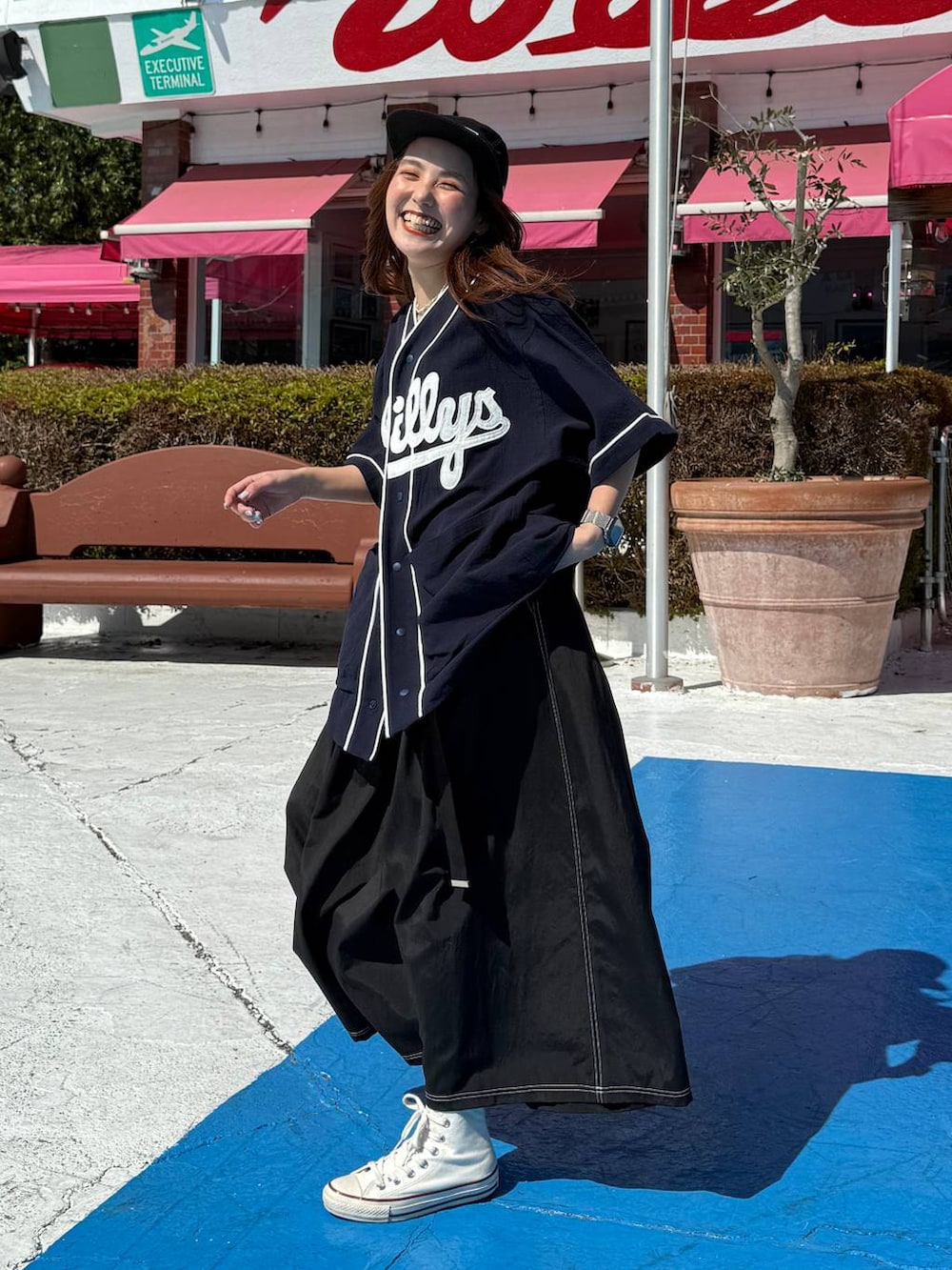 ブラック系のキャップを着用したレディースの春コーディネートの2枚目の写真