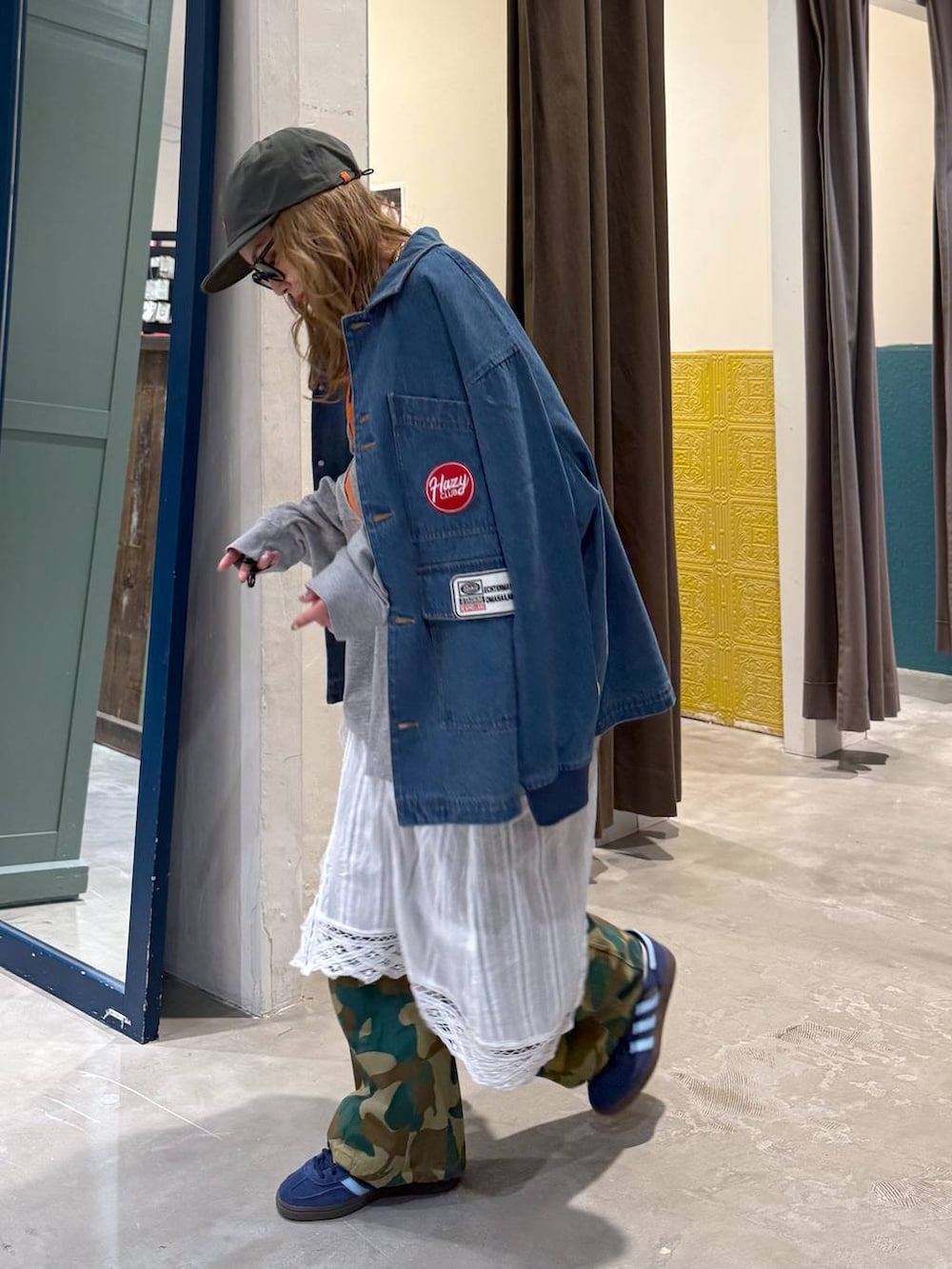 ホワイト系のスカート、グリーン系のキャップを着用したレディースの冬コーディネートの3枚目の写真