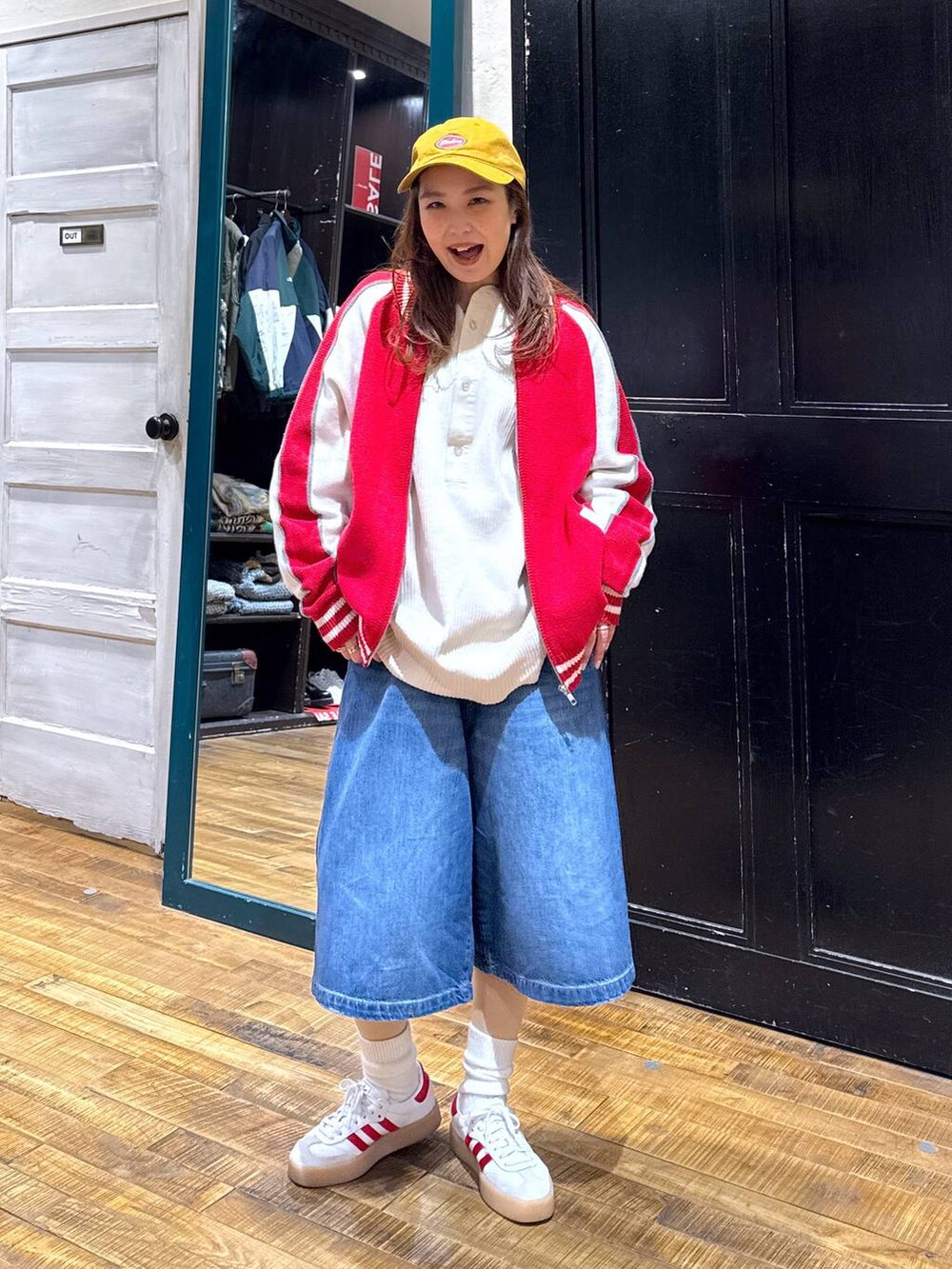 ブルー系のデニムパンツ、ホワイト系のTシャツ/カットソー、レッド系のカーディガン/ボレロを着用したレディースの冬コーディネートの2枚目の写真