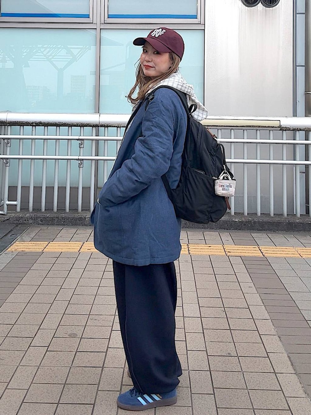 ブルー系のテーラードジャケット、ベージュ系のシャツ/ブラウス、レッド系のキャップを着用したレディースの冬コーディネートの3枚目の写真