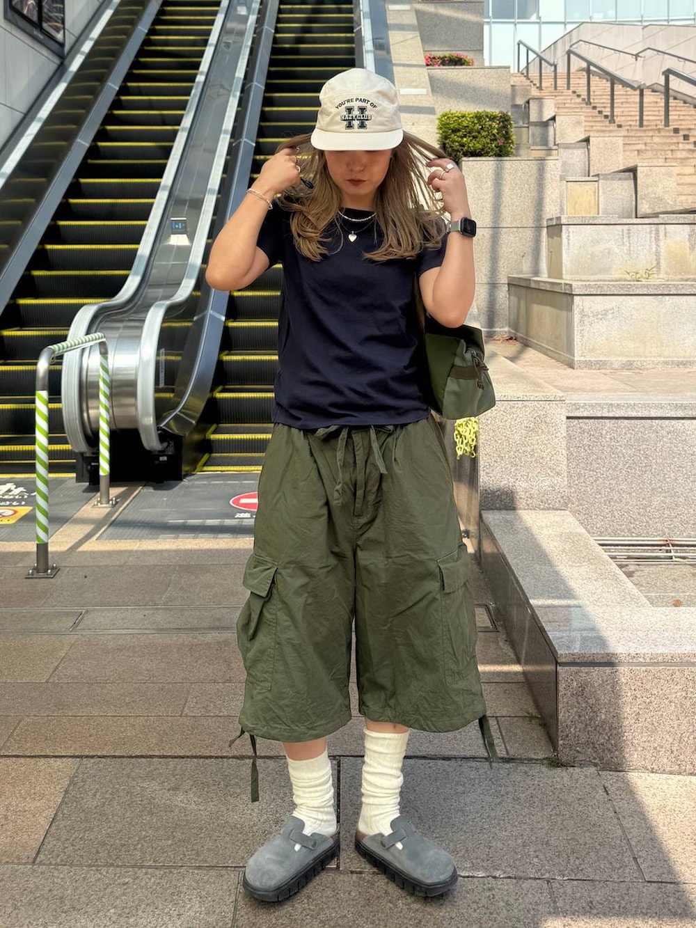 ブルー系のTシャツ/カットソー、グリーン系のカーゴパンツを着用したレディースの春コーディネートの3枚目の写真