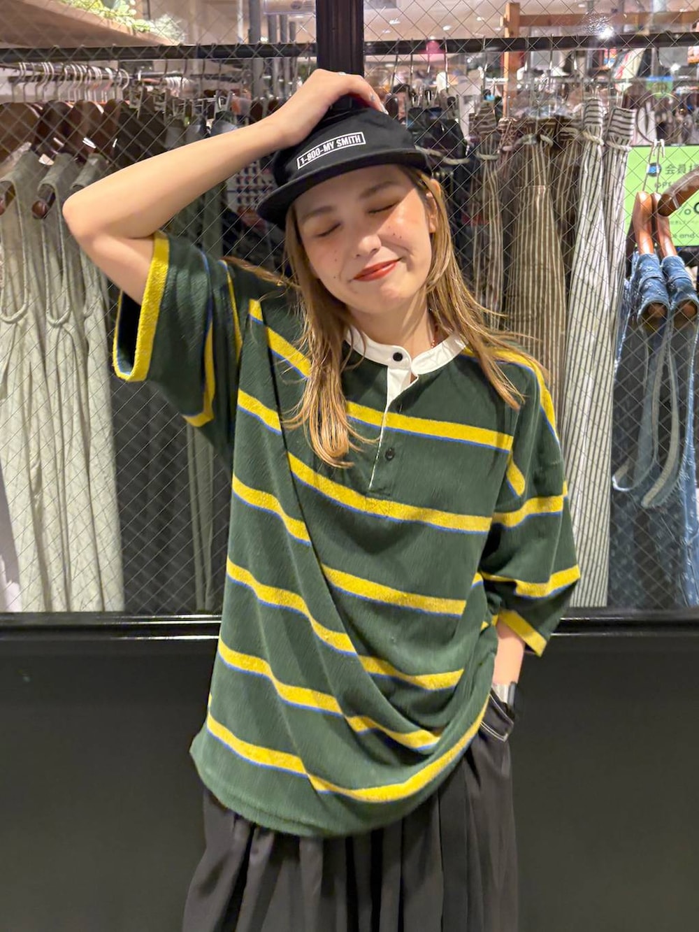 グリーン系のTシャツ/カットソー、ブラック系のキャップを着用したレディースの夏コーディネートの4枚目の写真