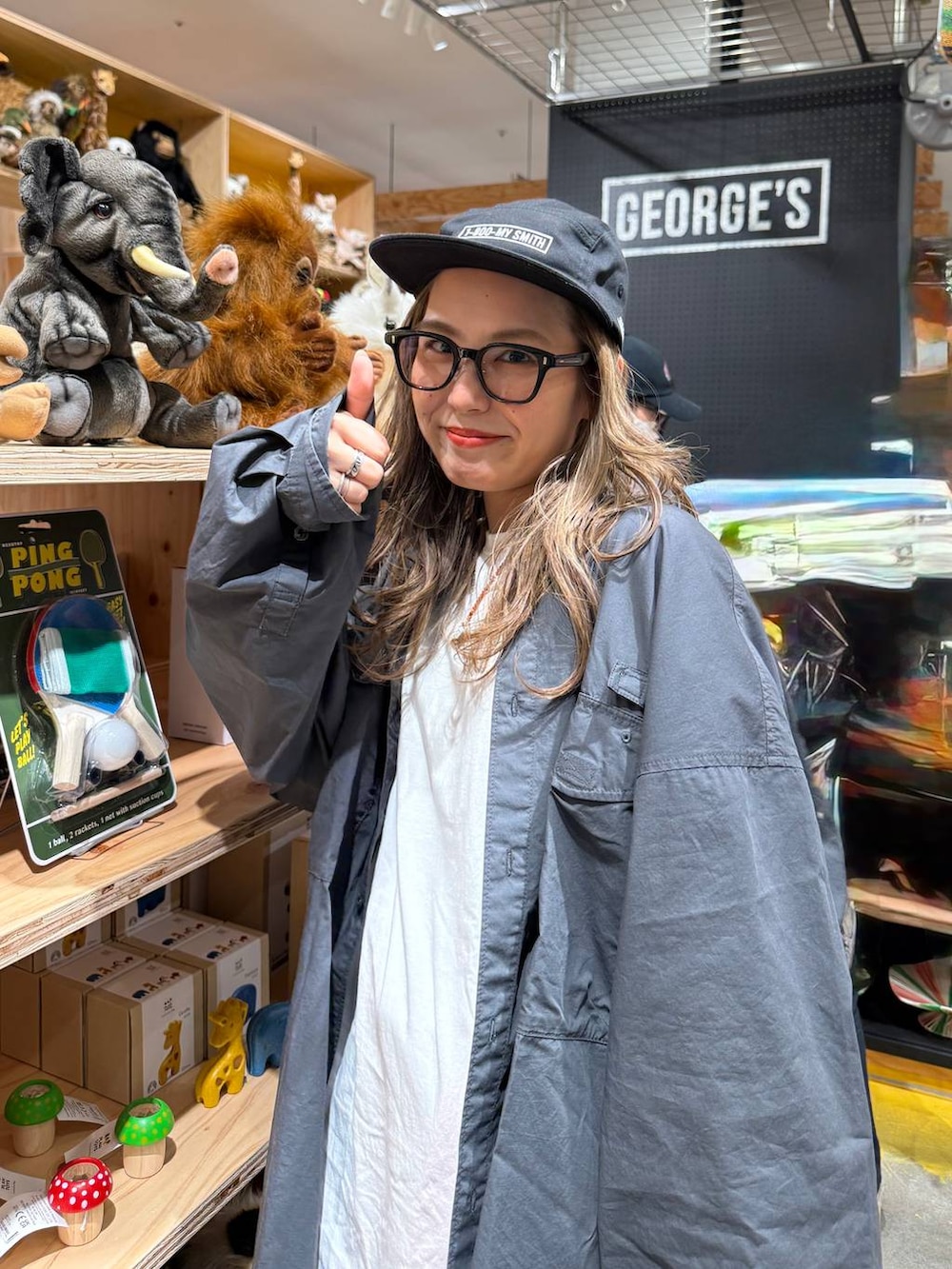 ブルー系のデニムパンツ、グレー系のエコバッグ/サブバッグ、ブラック系のキャップを着用したレディースの春コーディネートの3枚目の写真