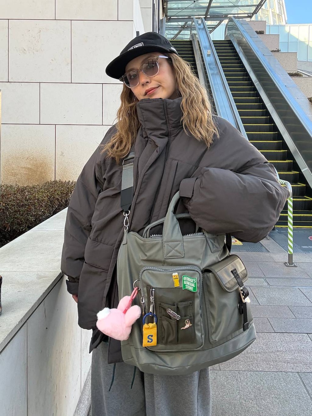 グレー系のその他パンツ、グレー系のダウンジャケット/コート、グリーン系のトートバッグを着用したレディースの冬コーディネートの2枚目の写真