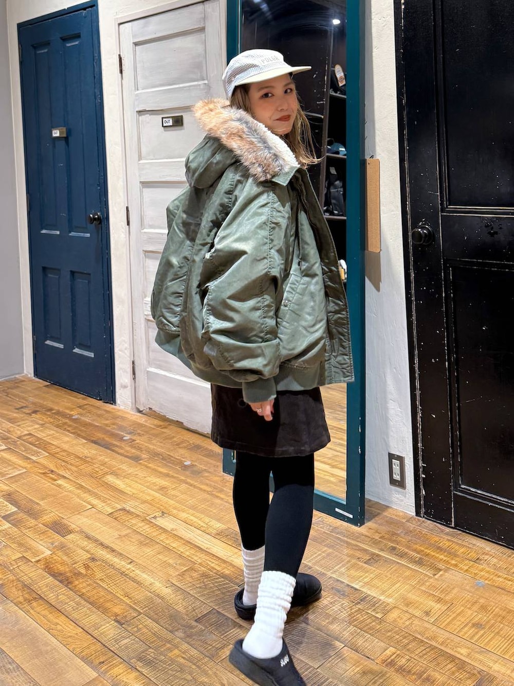 ブラウン系のスカート、グリーン系のブルゾン、レッド系のスウェットを着用したレディースの冬コーディネートの3枚目の写真