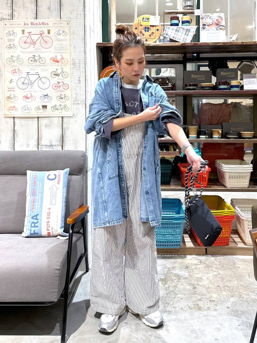ブラック系のショルダーバッグ、ブルー系のチュニックを着用したレディースの冬コーディネートの4枚目の写真