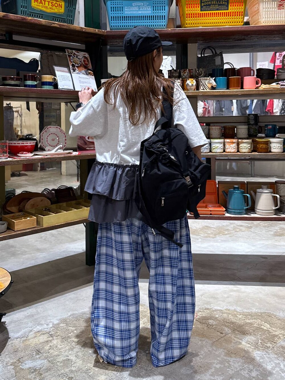 ベージュ系のスニーカー、ブラック系のバックパック/リュック、グレー系のTシャツ/カットソーを着用したレディースの春コーディネートの3枚目の写真