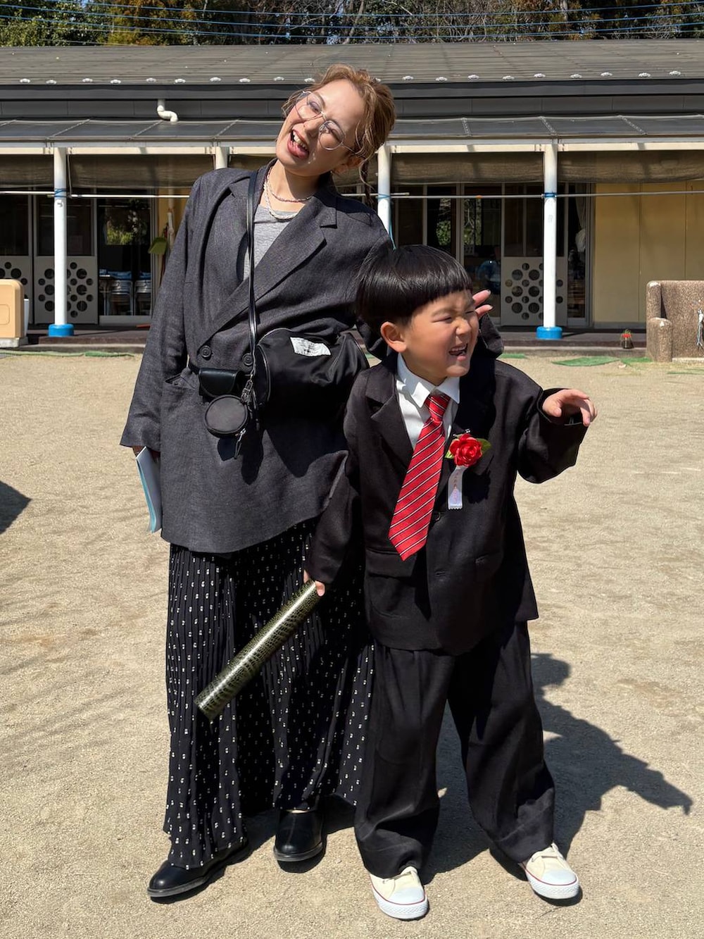 グレー系のTシャツ/カットソー、グレー系のテーラードジャケット、ブラック系のスカートを着用したレディースの春コーディネートの2枚目の写真