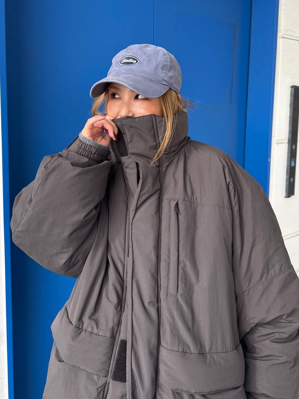 グレー系のダウンジャケット/コート、グレー系のスウェットパンツを着用したレディースの冬コーディネートの7枚目の写真