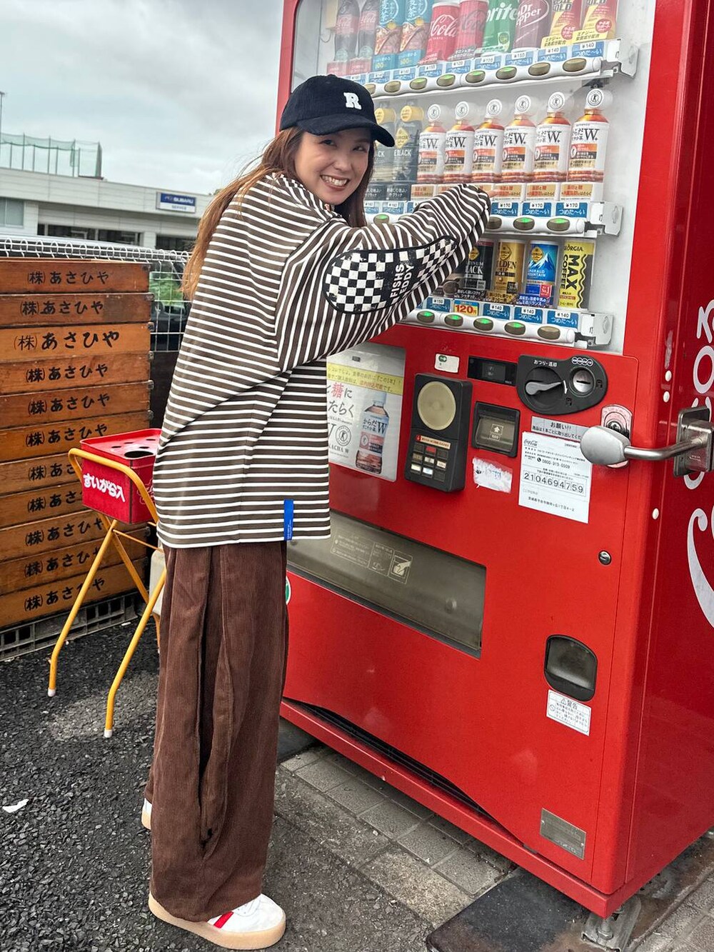 ベージュ系のショルダーバッグ、その他の長傘、ブラック系のキャップを着用したレディースの秋コーディネートの3枚目の写真