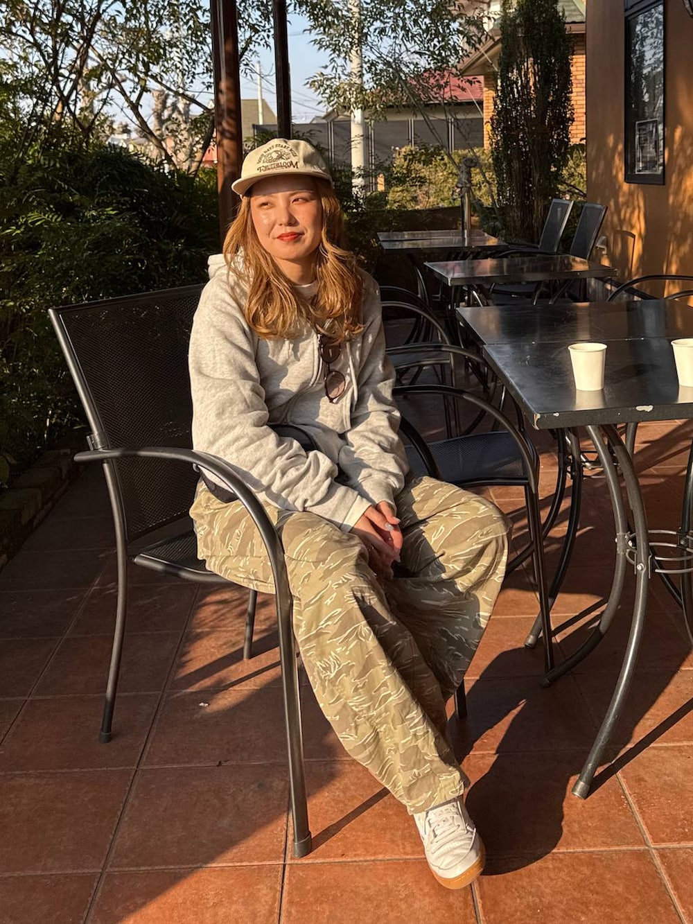 グレー系のボディバッグ/ウエストポーチ、ホワイト系のキャップを着用したレディースの冬コーディネートの3枚目の写真