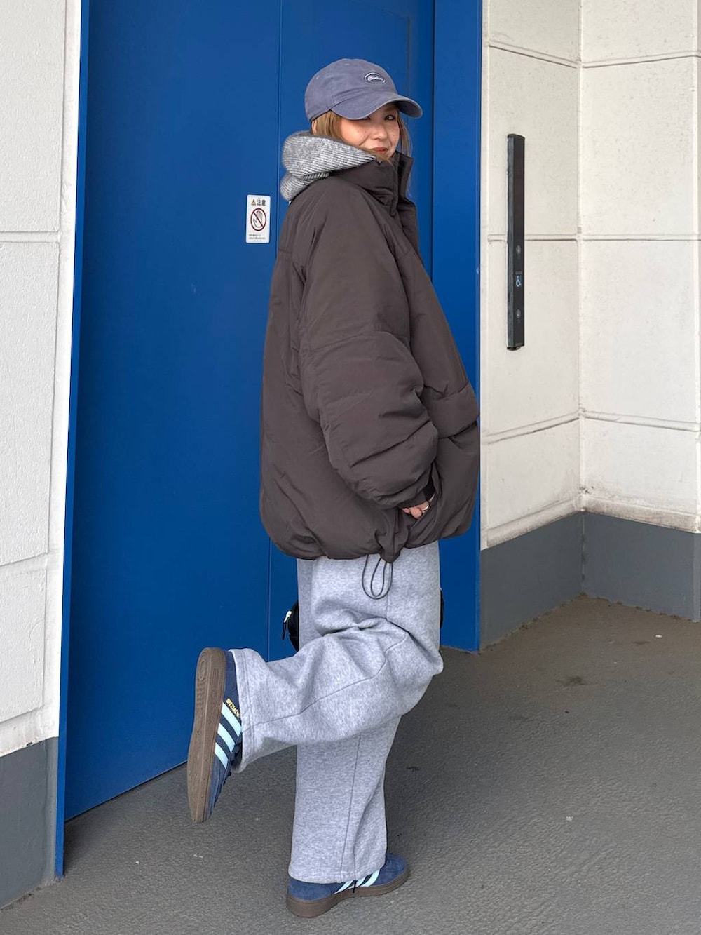 グレー系のダウンジャケット/コート、グレー系のスウェットパンツを着用したレディースの冬コーディネートの6枚目の写真