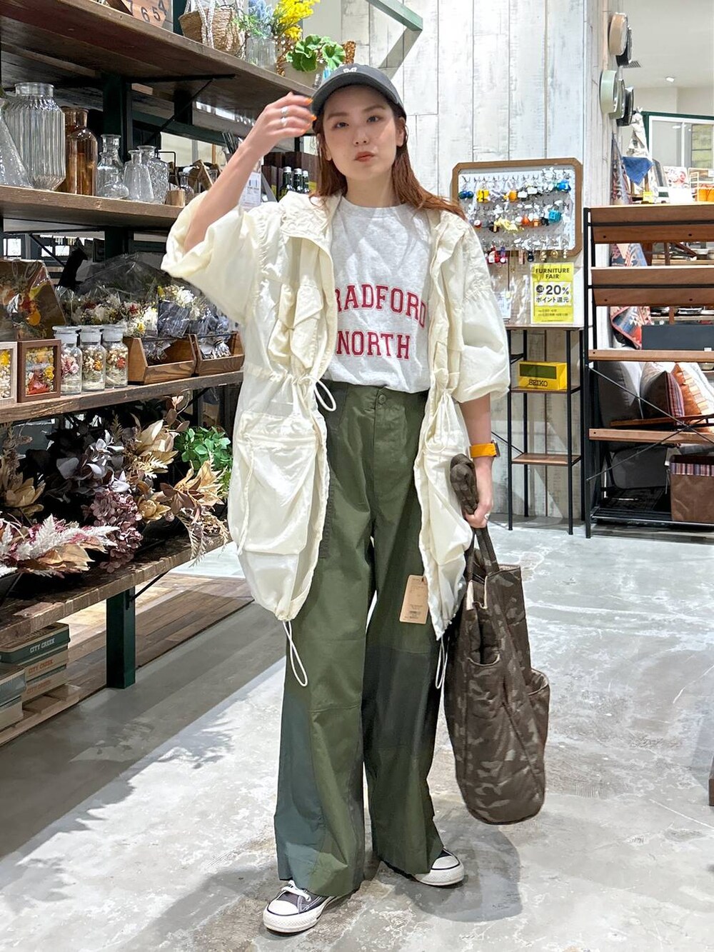 ベージュ系のブルゾン、グレー系のTシャツ/カットソー、ブラック系のキャップを着用したレディースの春コーディネートの2枚目の写真