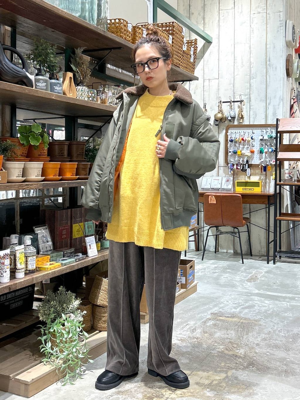 ブラック系のローファー、イエロー系のニット/セーター、ブラウン系のその他パンツを着用したレディースの冬コーディネートの2枚目の写真
