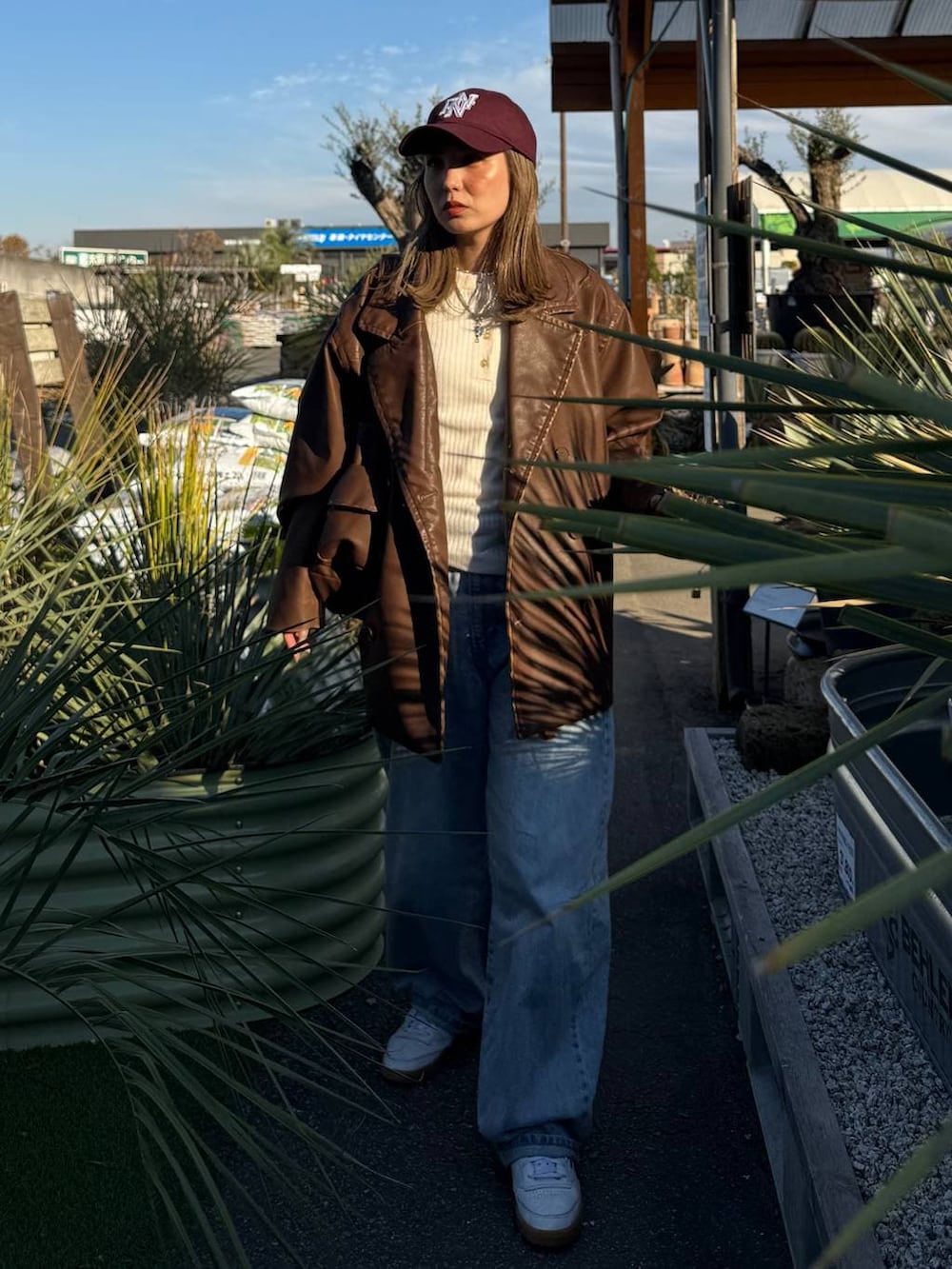 ブルー系のデニムパンツ、ブラウン系のその他アウター、ブラウン系のショルダーバッグを着用したレディースの秋コーディネートの2枚目の写真