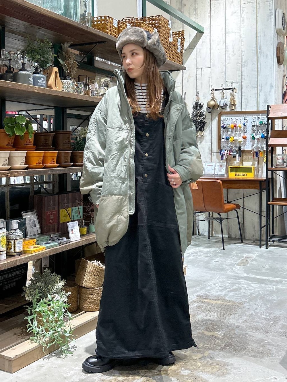 グリーン系のブルゾン、ブラック系のブーツ、ホワイト系のTシャツ/カットソーを着用したレディースの冬コーディネートの2枚目の写真