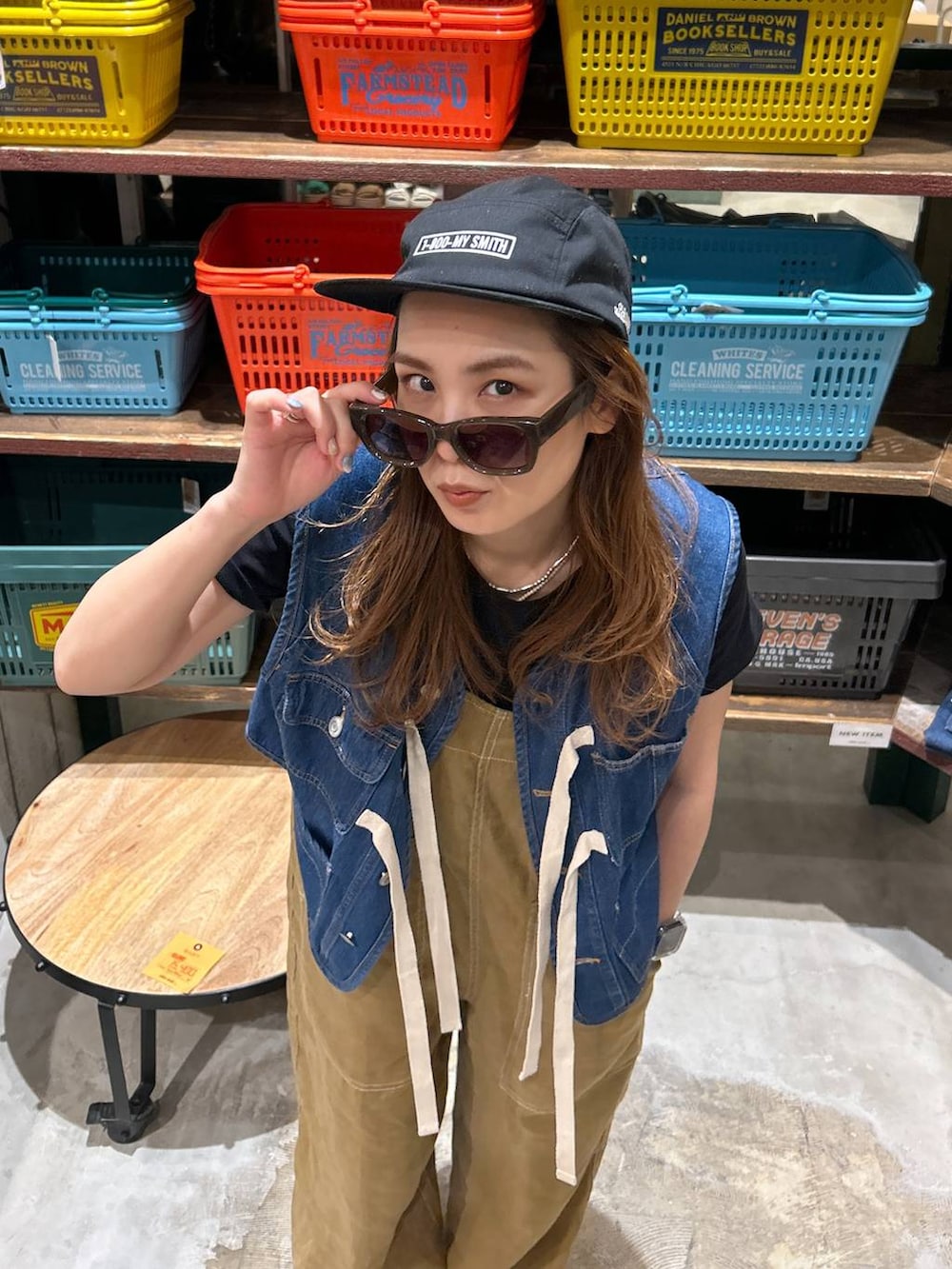 ブラック系のTシャツ/カットソー、ブルー系のベスト、ブラック系のサンダルを着用したレディースの春コーディネートの5枚目の写真