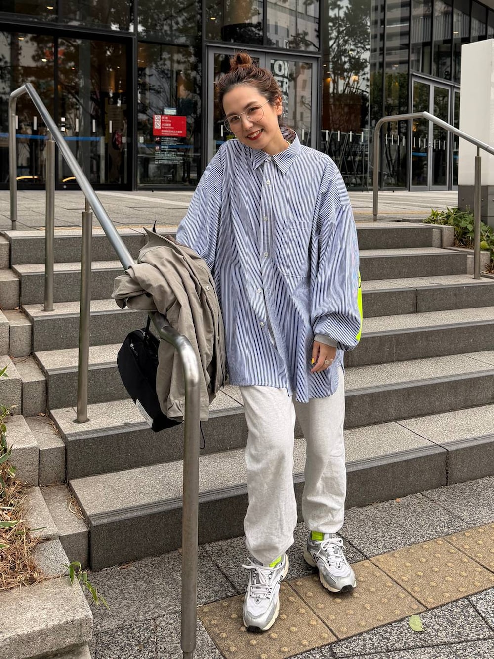 グレー系のスウェットパンツ、グリーン系のミリタリージャケットを着用したレディースの春コーディネートの3枚目の写真