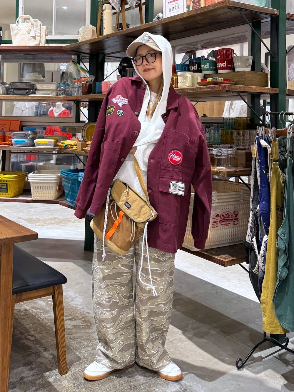 ホワイト系のパーカー、ベージュ系のキャップを着用したレディースの春コーディネートの3枚目の写真