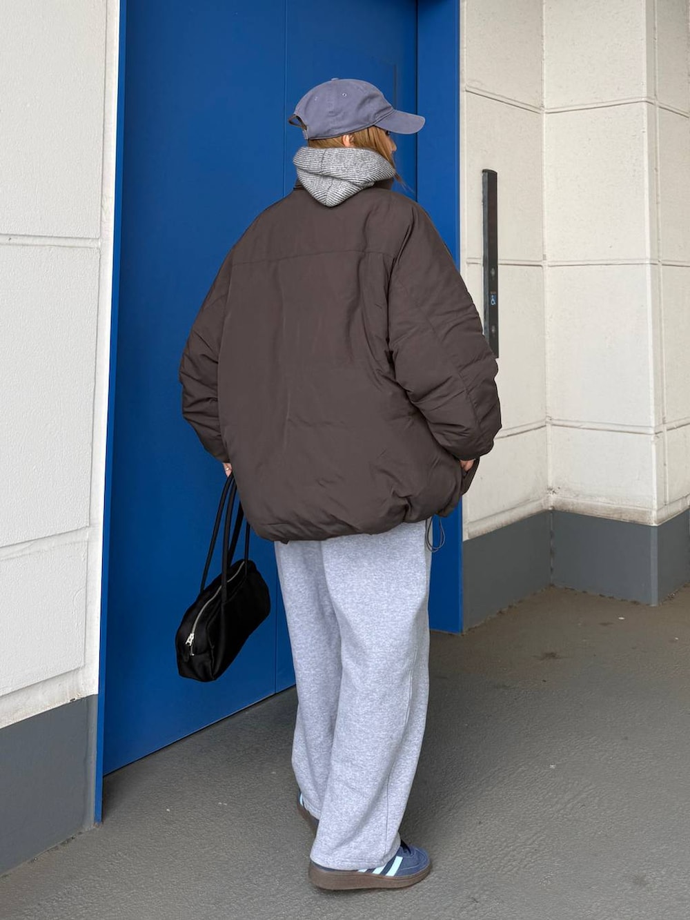 グレー系のダウンジャケット/コート、グレー系のスウェットパンツを着用したレディースの冬コーディネートの5枚目の写真