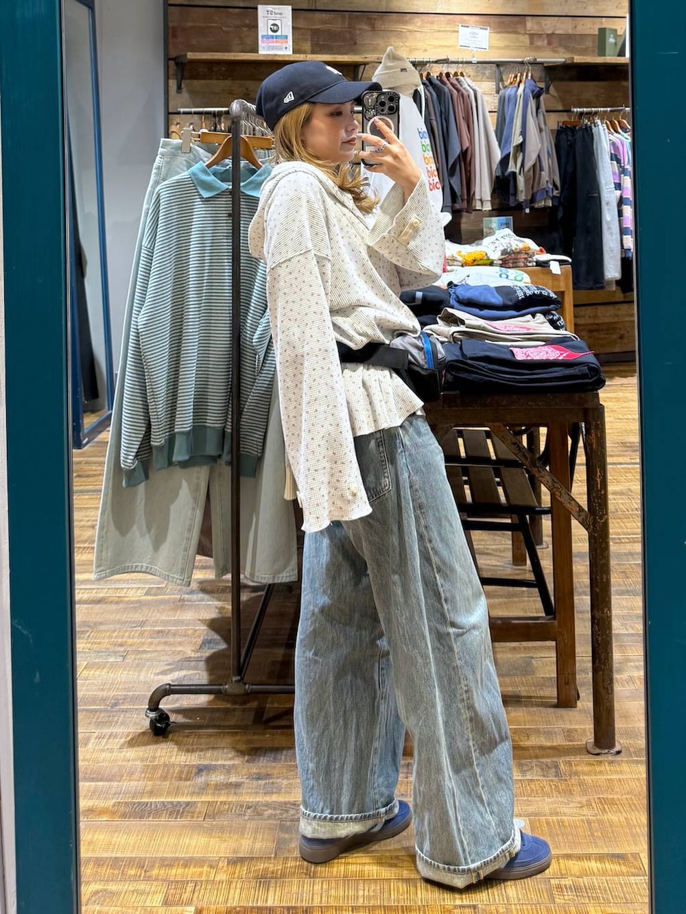 ブルー系のデニムパンツ、ベージュ系のパーカー、グレー系のボディバッグ/ウエストポーチを着用したレディースの冬コーディネートの4枚目の写真