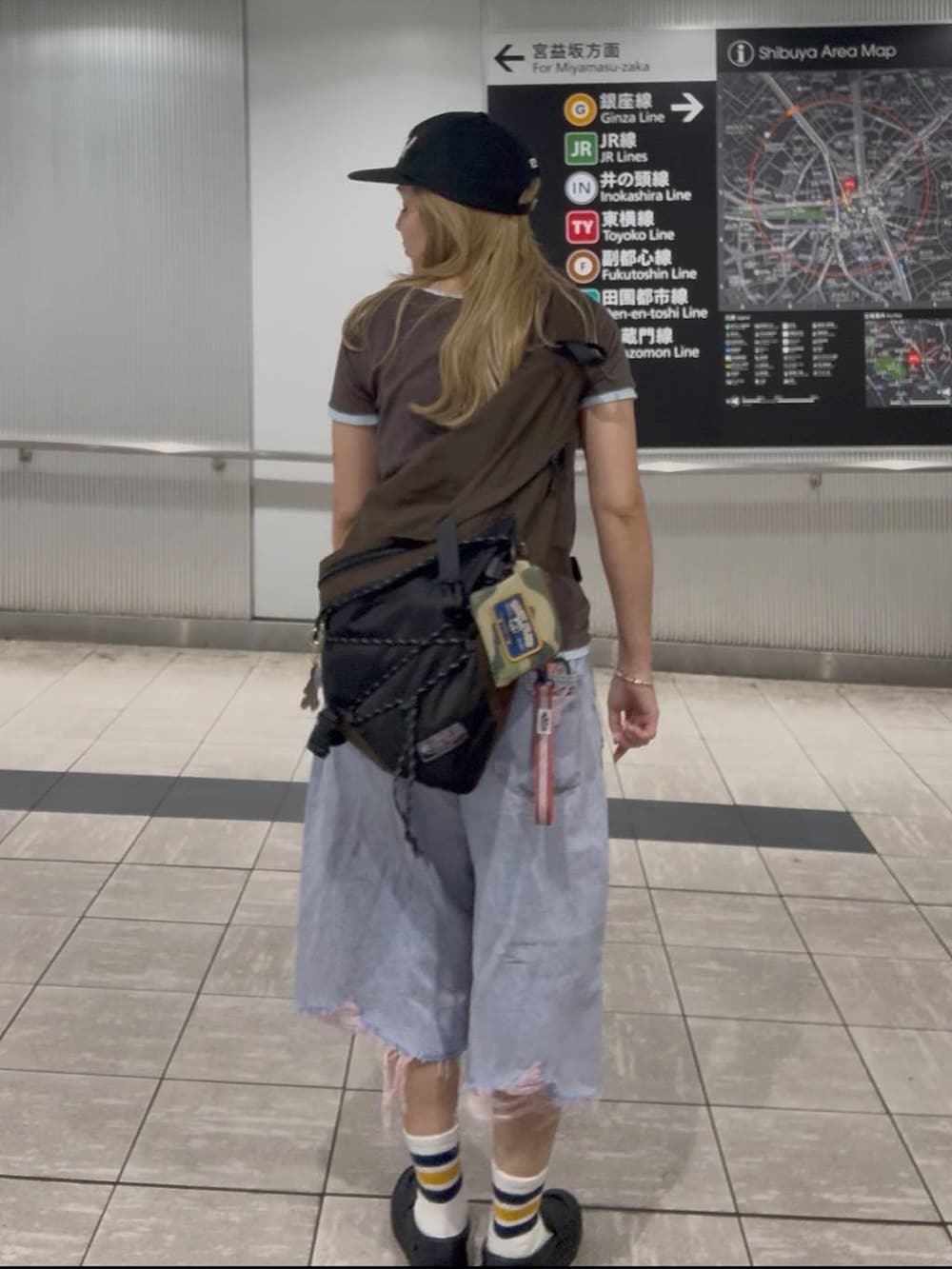 ピンク系のデニムパンツ、ブラウン系のTシャツ/カットソー、ベージュ系のボディバッグ/ウエストポーチを着用したレディースの夏コーディネートの2枚目の写真