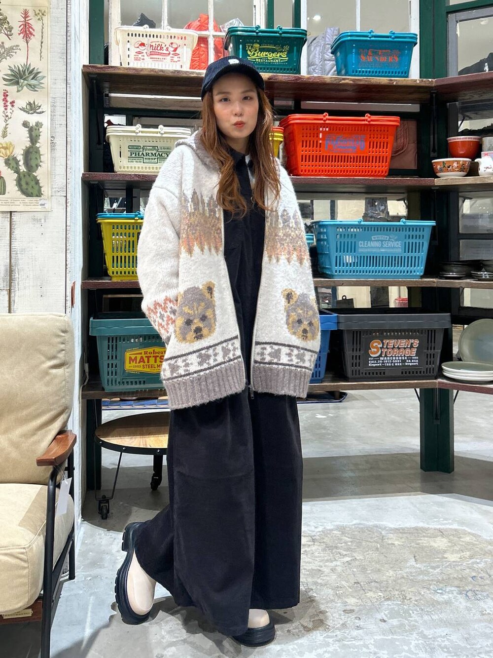 ブラック系のワンピース、ベージュ系のブーツ、ブラック系のキャップを着用したレディースの秋コーディネートの3枚目の写真