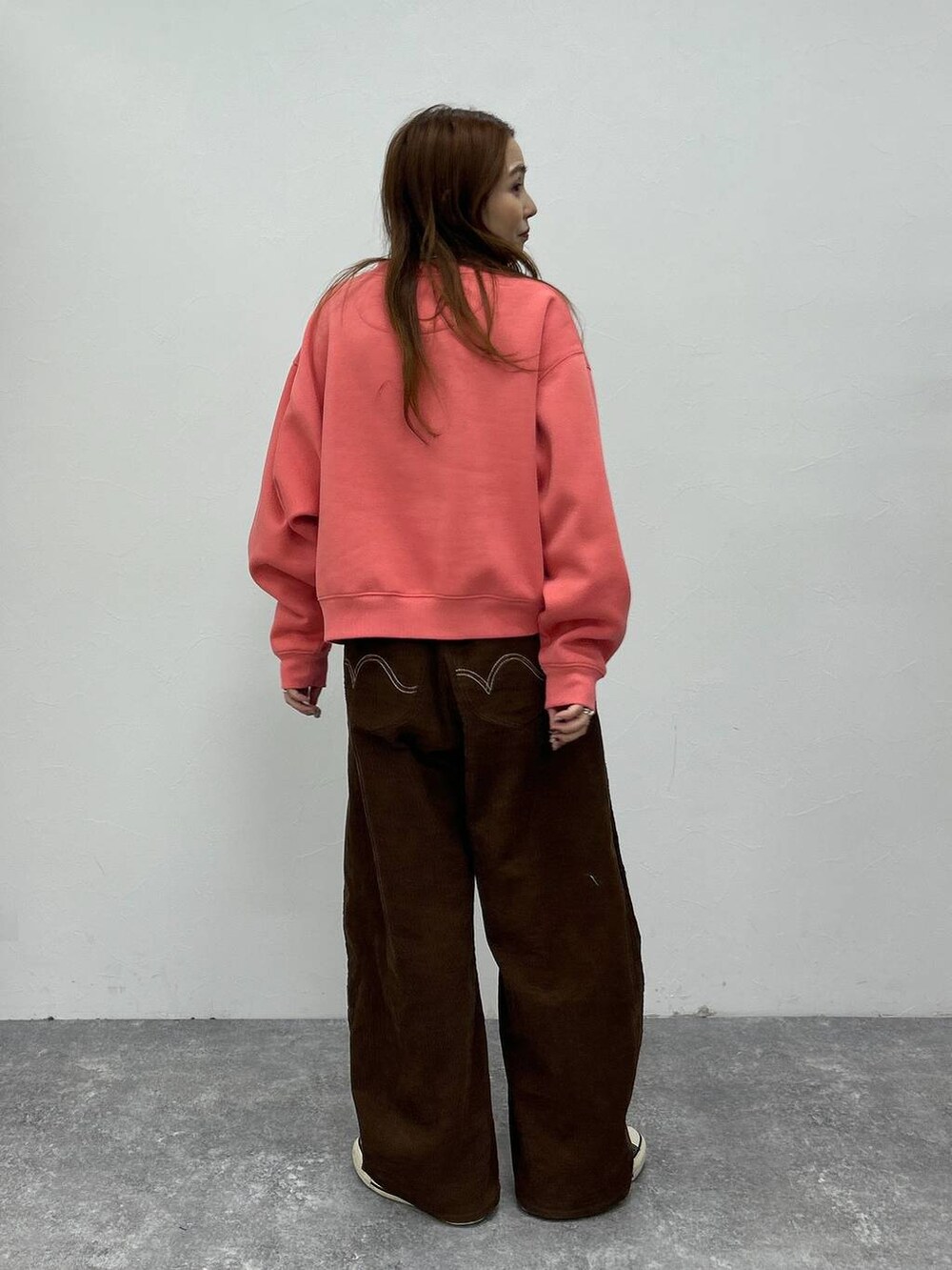 ピンク系のスウェットを着用したレディースの秋コーディネートの5枚目の写真