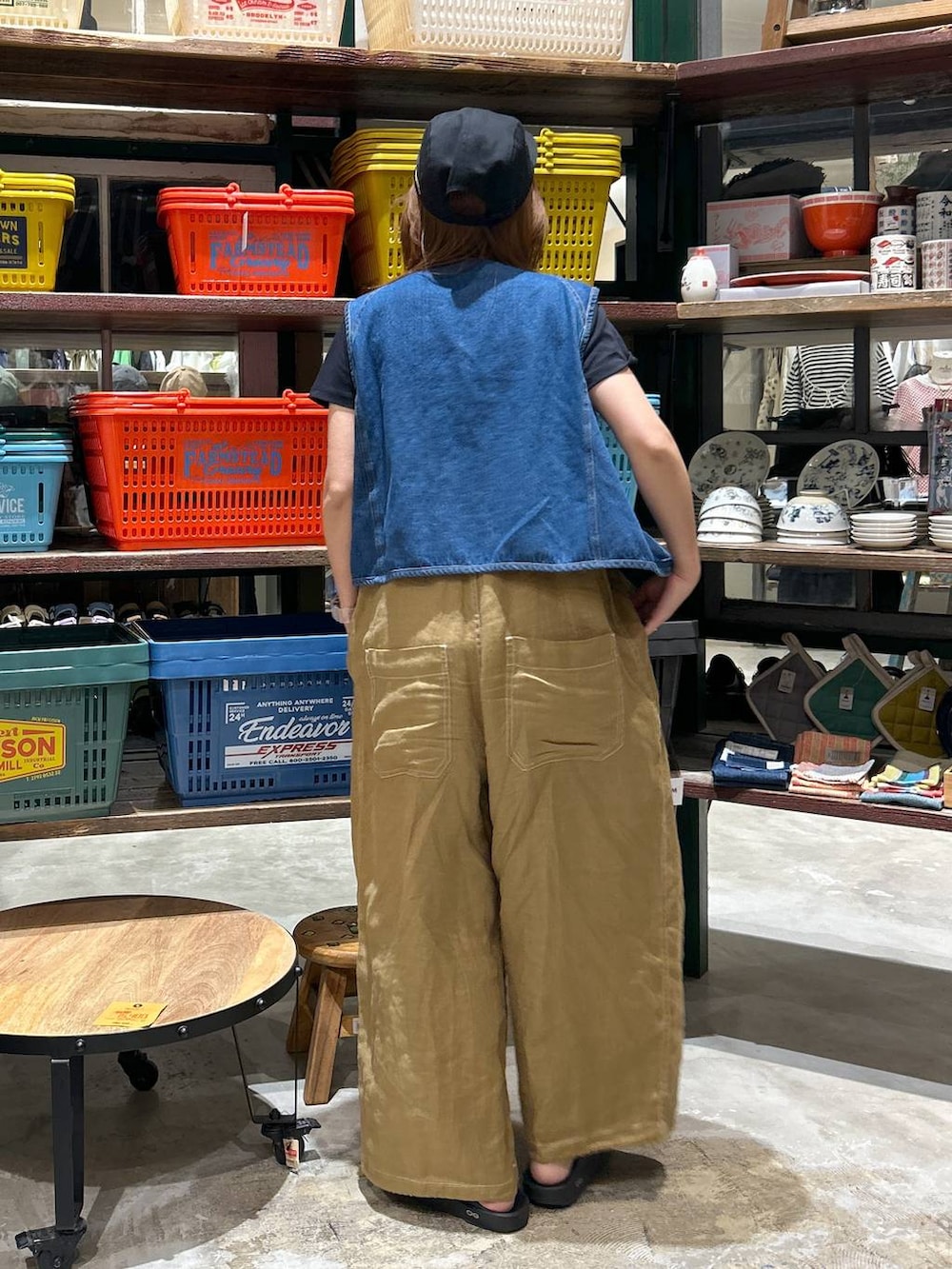 ブラック系のTシャツ/カットソー、ブルー系のベスト、ブラック系のサンダルを着用したレディースの春コーディネートの4枚目の写真